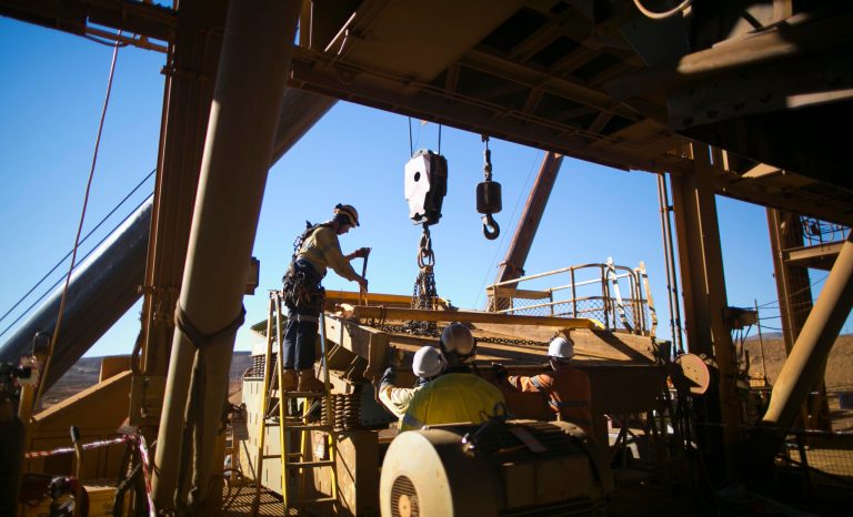 Rope access rigger wearing a fall safety protection helmet and harness