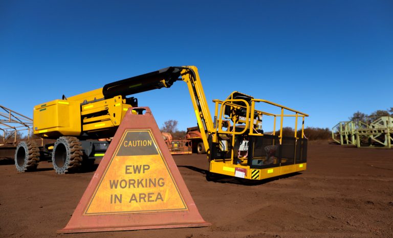 Elevated work platform caution warning triangle sign placing on the ground